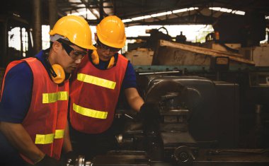 İş güvenliği kavramı: Profesyonel metal dönüştürme teknisyenlerinden oluşan kolektif takım çalışması çalışanları güvenli, sağlıklı ve çalışma kalitesini korumak için etkili bir şekilde çalışıyor