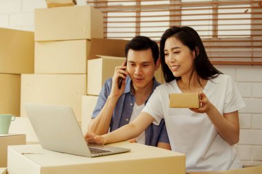 KOBİ 'leri kullanan Asyalı çiftler ürünlerini İnternet üzerinden sipariş veren ve mutlu bir şekilde satışa yardımcı olan müşterilere ulaştırıyorlar: Evden Çalışmak: Seçici Odaklanma 