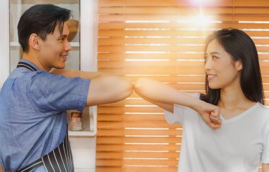 Çiftler mutfakta birlikte takılırken eğleniyorlar, koronavirüsün yayılmasını önlemek için dirseklerine vuruyorlar, onları kucaklayarak veya tokalaşarak selamlıyorlar. Evin içinde el sıkışmayın.