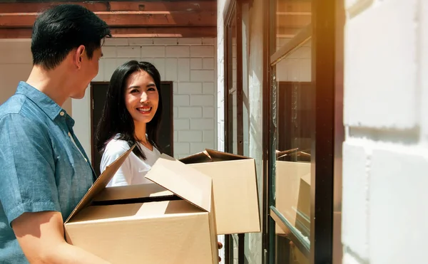 Young couples planning their families, moving into a new home,family happiness and living together : Asian couple brings home accessories boxes to the door of their family's new home with happy smile