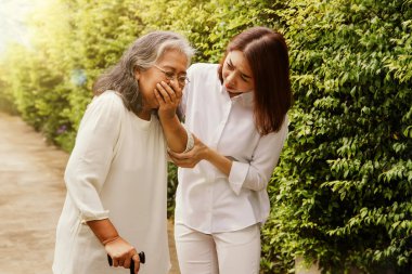 Yaşlı sağlık hizmetleri kavramı: Solunum hastalığından sürekli hasta olan yaşlı bir anneye bakan kız çocuğunun öksürüğü, annesinin kollarına destek oldu: Seçici Odaklanma