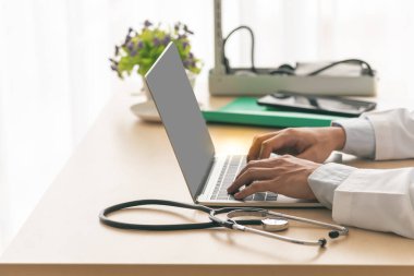 Doktor bilgisayarı kullanarak hastaların geçmişini ve semptomlarını kaydediyor..