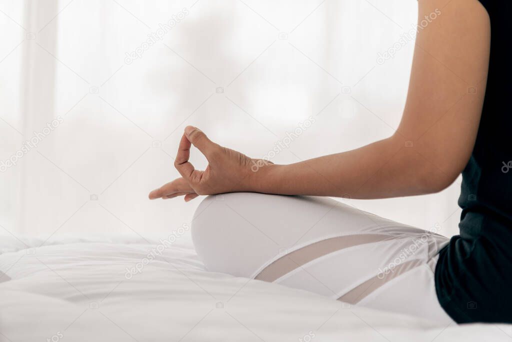 The women are practicing yoga in the basic position On a white bed,  which is a warm-up and meditation exercise, concept to health care and recreation