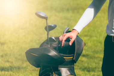 Golf atletleri, spor ve dinlenme konsepti için bulanık yeşil çimenli çantalarda bir sürü golf sopası olan.