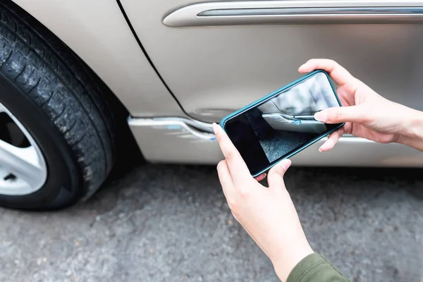 携帯電話を使用している女性事故による自動車の被害を写真に撮る保険代理店の証拠として 人々と交通保険の概念に — ストック写真