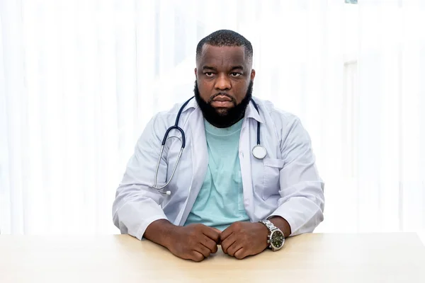 Portrait images of African doctor Sitting and working on the desk at workplace, with white background, to people and health care concept.