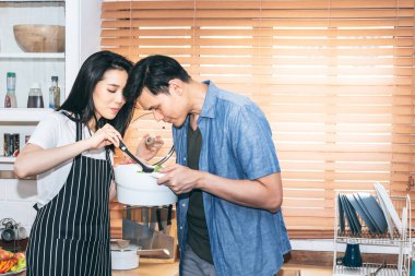 Asyalı genç çiftler, karı koca, birlikte mutludurlar. Mutfakta, insanlara ve gıda konseptine yemek yaparak aile içinde ortak aktiviteler düzenlerler..