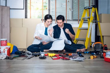 Asyalı bir koca ve çekici bir eş birlikte çalışıyor ve ev yenileme, aile ve konut iyileştirme konseptini planlamak için bir plan arıyorlar..