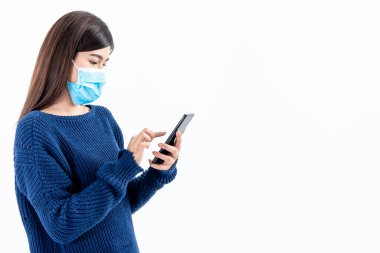 Asyalı çekici bir kadının portre görüntüleri, cerrahi maske takıyor ve cep telefonu kullanıyor beyaz arka planda, insanlara sağlık hizmeti ve teknoloji konsepti.