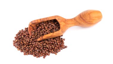 Beyaz arka planda izole edilmiş, ahşap kepçeli Gine biberi taneleri. Melegeta, timsah biberi ya da mahlab. Cennet tanecikleri