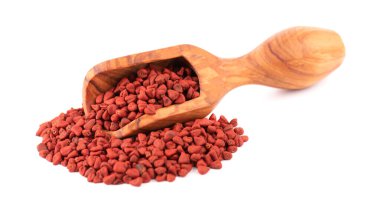 Tahta kepçeyle Annatto tohumları, beyaz arka planda izole. Başarı tohumları, bixa orellana. Yemek ve yemek pişirmek için doğal boya. Yakın plan.