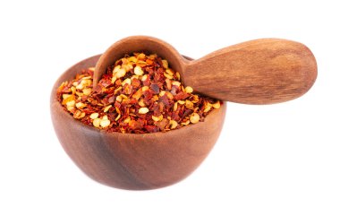 Kırmızı biber ve kırmızı biber, ahşap kâse ve kaşıkta, beyaz arka planda izole edilmiş. Acı ve tatlı kırmızı biber ve tahıl karışımı.