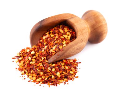 Beyaz arka planda izole edilmiş, ahşap kepçe içinde kırmızı biber ve kırmızı biber. Acı ve tatlı kırmızı biber ve tahıl karışımı.