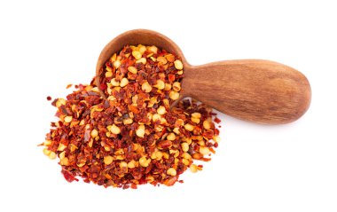 Kırmızı biber ve kırmızı biber, tahta kaşıkta, beyaz arka planda izole edilmiş. Acı ve tatlı kırmızı biber ve tahıl karışımı.