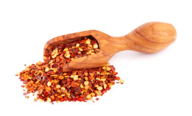 Beyaz arka planda izole edilmiş, ahşap kepçe içinde kırmızı biber ve kırmızı biber. Acı ve tatlı kırmızı biber ve tahıl karışımı.