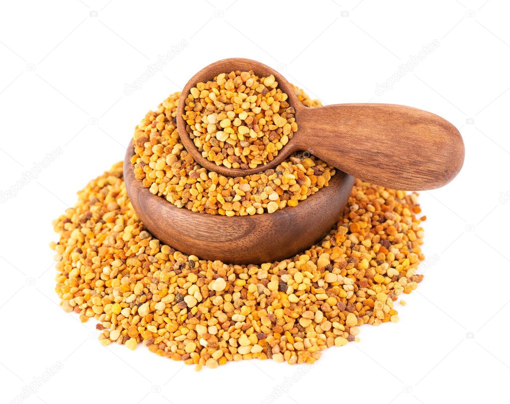Flower pollen grains in wooden bowl and spoon, isolated on white background. Pile of bee pollen or perga