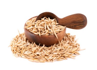 Ahşap kasede ve kaşıkta soyulmamış yulaf tohumları, beyaz arka planda izole edilmiş. Organik kuru yulaf tohumları