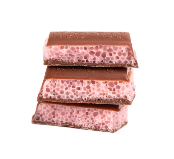 Pedaços de chocolate poroso isolados no fundo branco. Chocolate aerado de morango rosa. — Fotografia de Stock