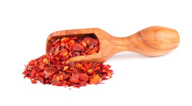 Beyaz arka planda izole edilmiş zeytin kepçesinde kurutulmuş kırmızı biber taneleri. Kırmızı biberli doğranmış kırmızı biber. Baharatlar ve bitkiler.