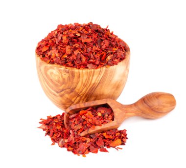 Zeytin kabında kurutulmuş kırmızı biber taneleri ve kepçe, beyaz arka planda izole edilmiş. Kırmızı biberli doğranmış kırmızı biber. Baharatlar ve bitkiler.