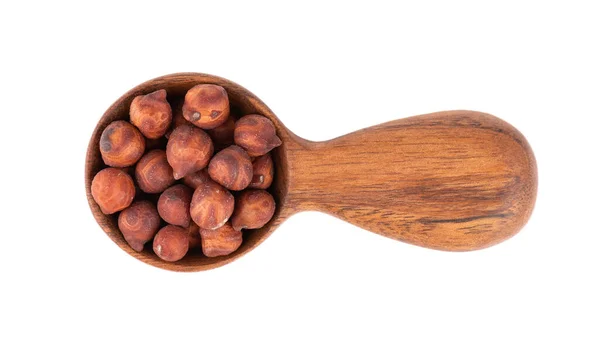 Pile of brown chickpeas in wooden spoon, isolated on white background. Brown chickpea. Garbanzo, bengal gram or chick pea bean. Top view. — Stockfoto