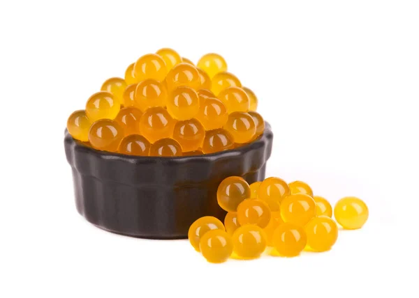 Yellow tapioca pearls for bubble tea isolated on white background. Tapioca pearls in black ceramic bowl. — Stock Photo, Image