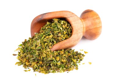 Tahta kepçeyle tohum karıştırılmış kurutulmuş yeşil biber taneleri, beyaz arka planda izole edilmiş. Doğranmış jalapeno, habanero ya da kırmızı biber. Baharatlar ve bitkiler. Üst görünüm.