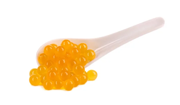 Yellow tapioca pearls for bubble tea isolated on white background. Tapioca pearls in ceramic spoon. — Stock Photo, Image