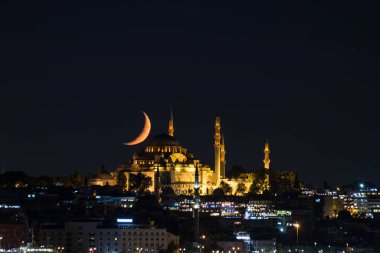 Ay, geceleri Fatih Camii 'nin üzerinde hilal gibi duruyor.