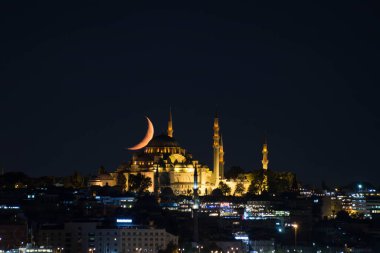 Ay, geceleri Fatih Camii 'nin üzerinde hilal gibi duruyor.