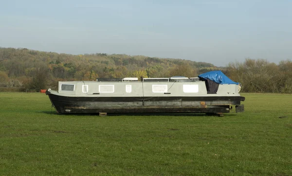 Obsolete narrow boat in a field