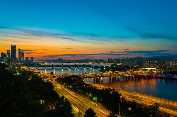 Han Nehri 'ndeki köprüde trafik varken Seul şehir merkezinin en üst manzarası. Güney Kore. Finansal bölge ve Asya 'nın akıllı kentsel kentindeki iş merkezleri. Gün batımında gökdelen ve yüksek binalar.