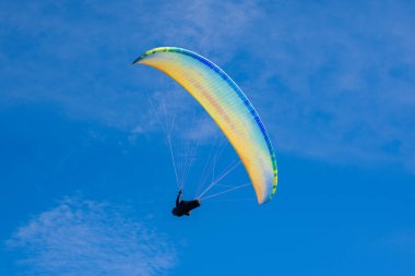Mavi gökyüzü arka planında renkli bir paraglider. Sıra dışı spor.
