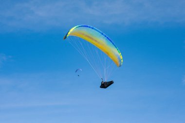 Mavi gökyüzü arka planında renkli bir paraglider. Olağanüstü bir spor. Çılgın hobi.