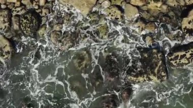Okyanus dalgalarının yukarıdan görünüşü kayalara ya da taşlara çarpıyor.. 