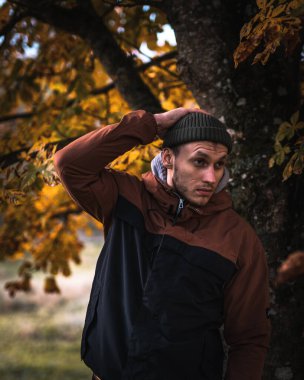 Sonbahar ormanında, dışarıda yürüyen, kalın elbiseli genç bir adam. Sonbahar havası. Yüksek kalite fotoğraf