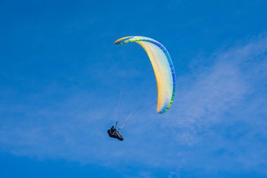 Mavi gökyüzü arka planında renkli bir paraglider uçar. Olağanüstü bir spor. Yüksek kalite fotoğraf