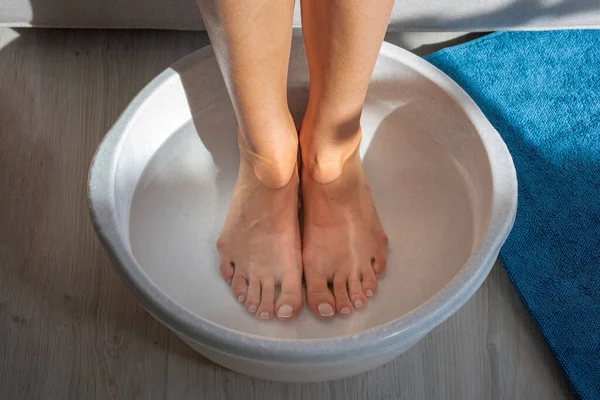 Mujer baño hecho con agua caliente y bicarbonato de sodio para sus pies. Remojo casero del baño para la piel seca de los pies — Foto de Stock