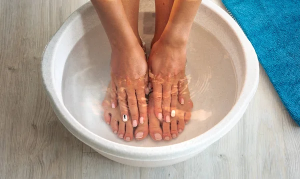 Frau legte Hände und Füße in Bad mit heißem Wasser und Backpulver zu Hause. Hausgemachtes Bad für trockene Füße — Stockfoto