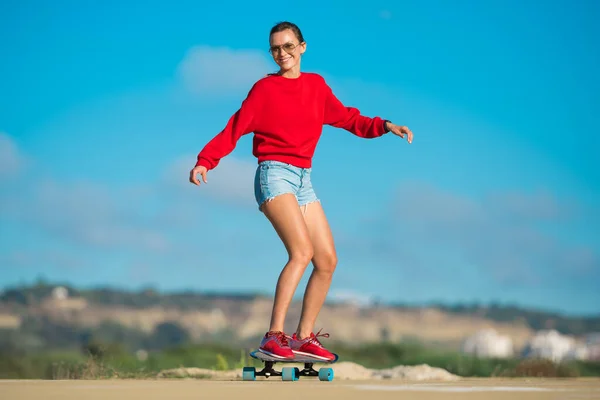 Jeune femme chevauchant longboard sur une journée d'été ensoleillée — Photo