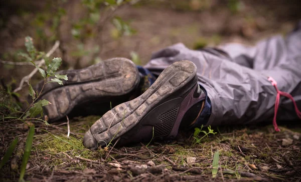 A dead man body lying on the ground In the woods. Dead body in the forest. Murder in the woods