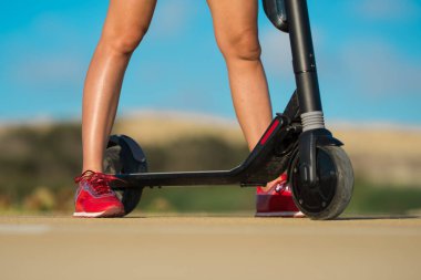 Güneşli yaz gününde elektrikli scooter sürmek.