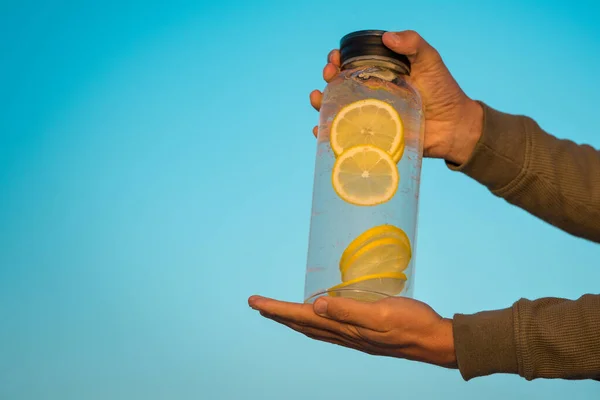 Homem segurando grande garrafa de água doce de limão. Bebidas saudáveis, dieta e conceito de desintoxicação — Fotografia de Stock