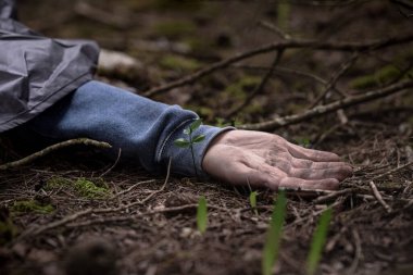 Ormanda yerde yatan ölü bir adam. Öldürülen adam.