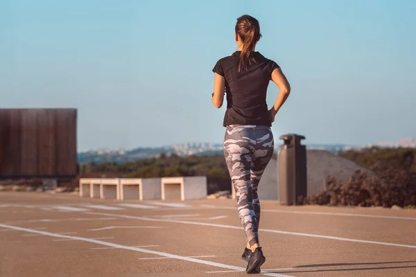 Jovem atleta corredor fitness mulher correndo na estrada. Desporto roupas apertadas. Fitness e conceito de bem-estar de treino — Fotografia de Stock