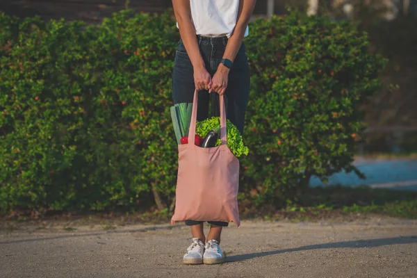 Frau mit pinkfarbenem Mehrwegbeutel mit frischem Biogemüse. Veganes Einkaufen auf pflanzlicher Basis. Gesunde Lebensmittel saubere Ernährung. Null Abfall, plastikfrei — Stockfoto