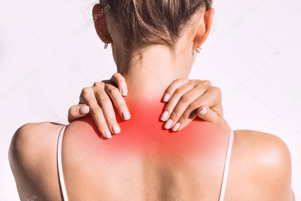 Closeup shot of woman from back having red spot of neck pain. Neck and shoulder pain and injury or muscle spasm. Back and spine disease. Female massaging her neck. Health care and medical concept
