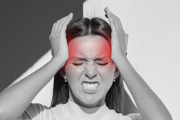 Junge Frau berührt ihre Schläfen und hat starke Spannungskopfschmerzen. Clusterkopfschmerz. Frauen leiden unter Migräne, Stress, Kater mit rotem Alarmakzent. Hände auf dem Kopf — Stockfoto