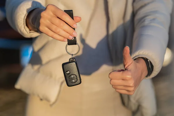 Een vrouw met de sleutel van haar nieuwe auto. Vrouw heeft een rijbewijs en is klaar om te rijden — Stockfoto