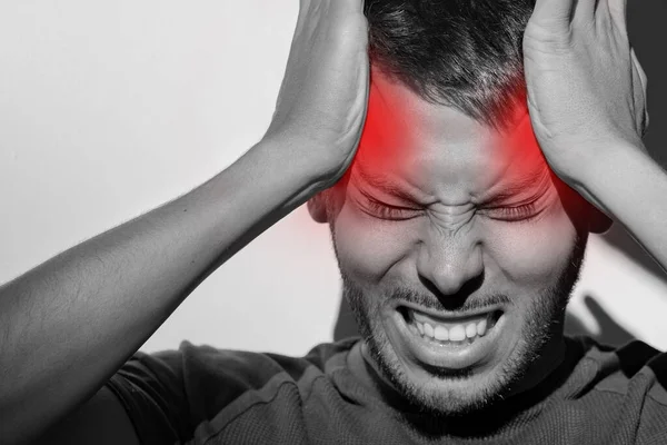 Nahaufnahme Porträt eines jungen Mannes, der an schmerzhafter Migräne oder starkem Spannungskopfschmerz leidet. Clusterkopfschmerzen, Stress. Hände auf den Kopf. Kopfschmerzen in den Schläfen — Stockfoto